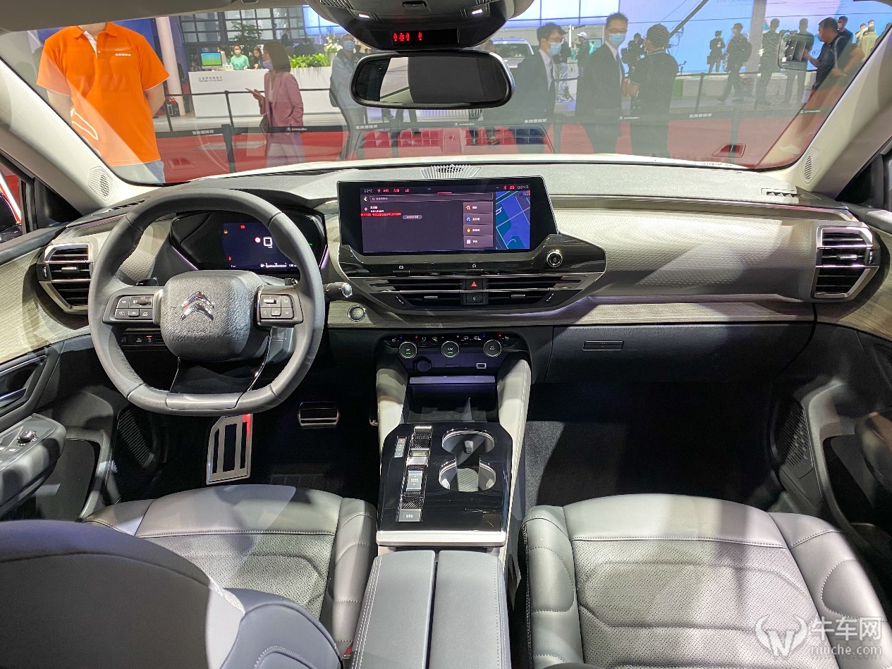 凡尔赛c5x的内饰采用了环抱式布局,中控运用了不规则设计,以浅色木纹